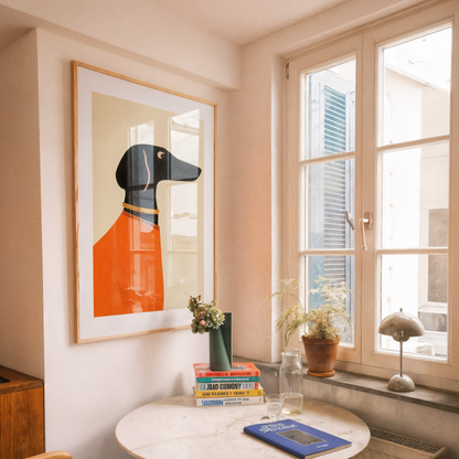 Small dining area with a round table, chairs, and a framed picture of a dog on the wall.