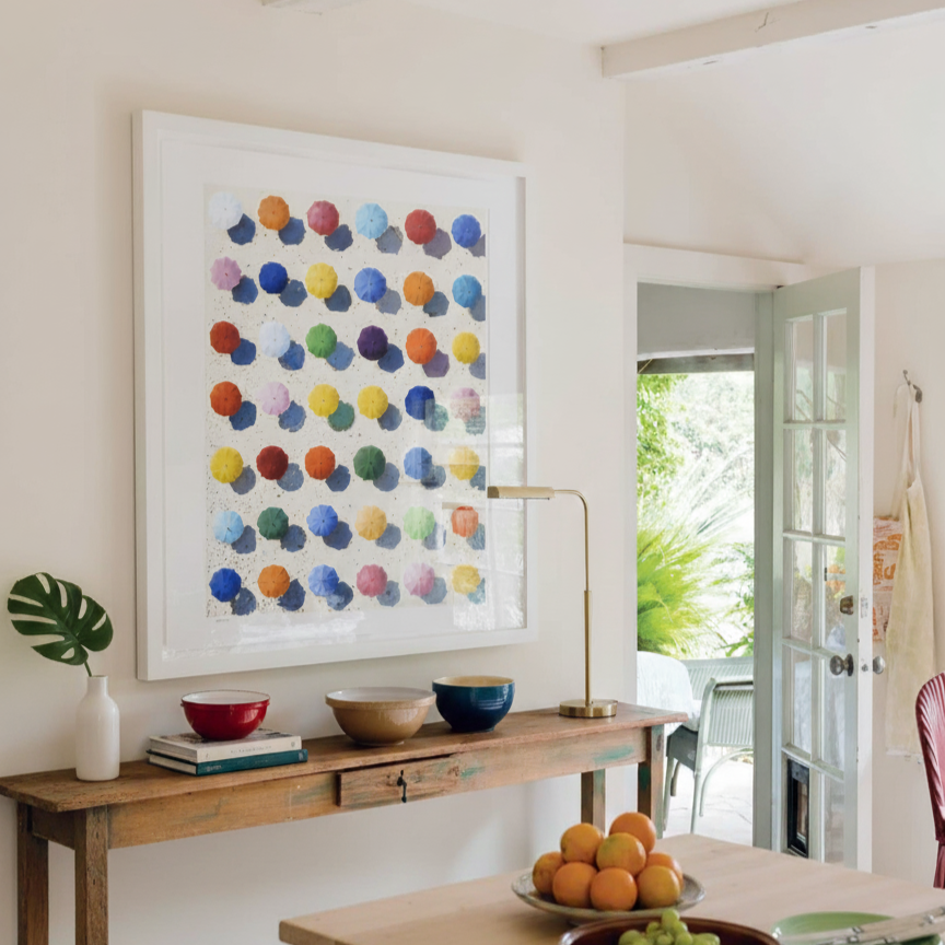 Modern interior with a wooden table, colorful abstract art, and decorative items.