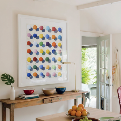 Modern interior with a wooden table, colorful abstract art, and decorative items.