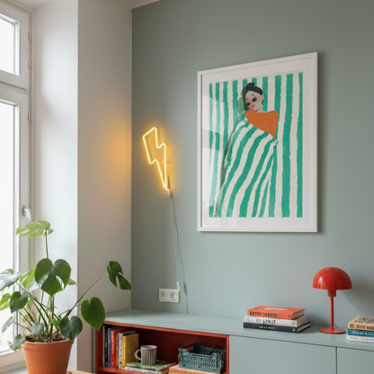 Modern interior with a neon light, framed artwork, and bookshelf.