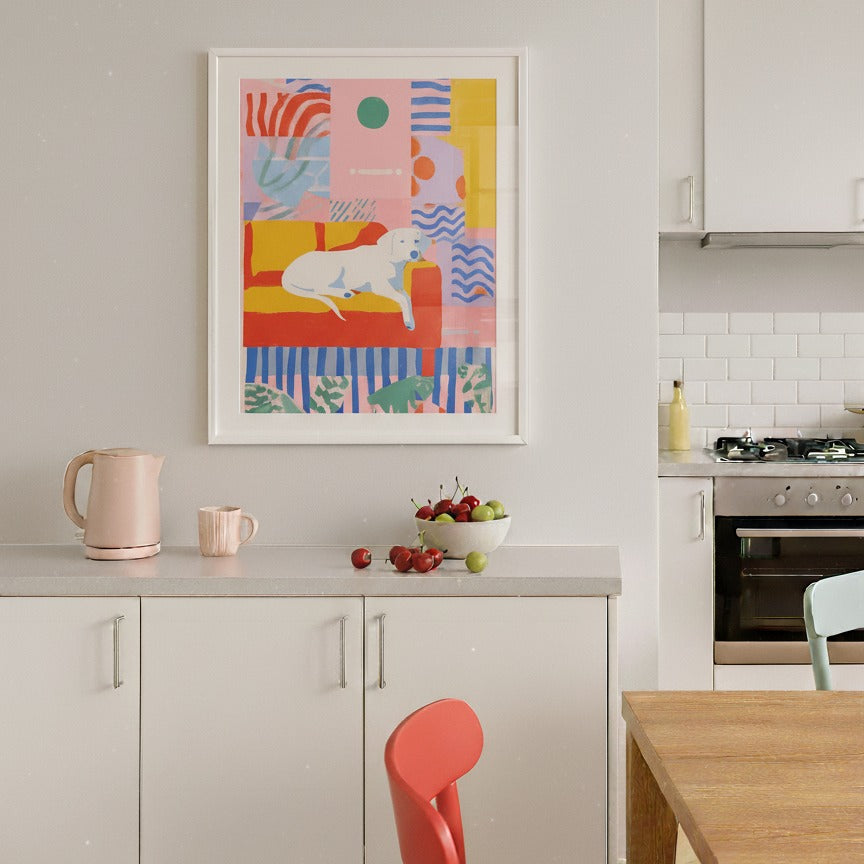 Kitchen interior with a colorful abstract painting on the wall, a red chair, and kitchen appliances.